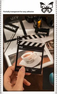 Detail showing a transparent PET clapperboard sticker used for vintage scrapbooking decoration