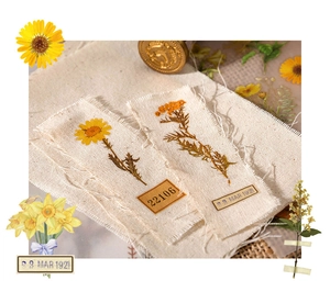 Detaillierte Nahaufnahme von Vintage-Stickern aus Baumwollleinen mit gelben botanischen Blumendrucken