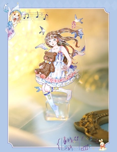 Detail of clear acrylic standee featuring a girl holding a teddy bear with lace skirt