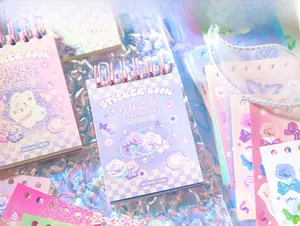 Close-up of holographic stickers and a spiral notebook with dreamlike pearlescent finish