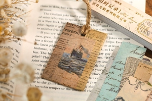 Vintage scrapbooking sticker set with antique ship illustration tag on an old book background