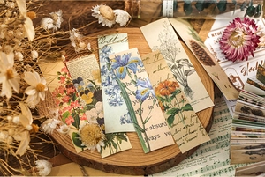 Macro view of vintage floral bookmarks with retro typography on a wooden tray with dried flowers