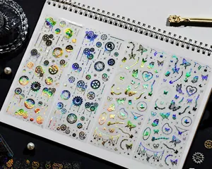 Detail view of colorful laser silver steampunk gear and butterfly stickers on a notebook
