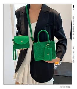 Detail of bright green felt handbag set with crocodile pattern and round handle