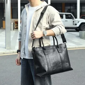 Men's black leather crossbody bag featuring dual handles and adjustable shoulder strap