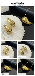 Detail showing gold teardrop pendant and stud earrings with hand-set pink and black rhinestones