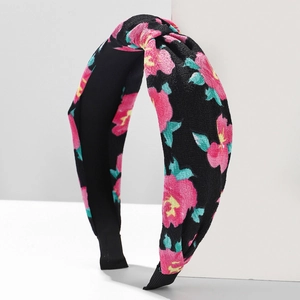 Floral knot headband for women featuring pink flowers on black fabric with a wide band