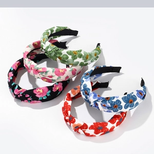 Detail of four floral knotted headbands in green, pink, blue and red patterns