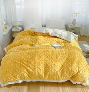 Close-up of yellow knit pattern texture and white lamb fleece lining of the thick blanket