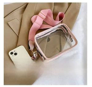 Detailed view of pink transparent PVC crossbody bag with floral scarf and wide canvas strap