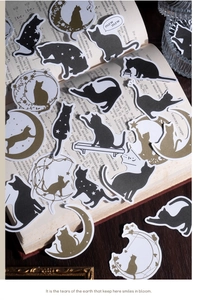 Artistic cat stickers with gold motifs displayed on vintage Russian book pages