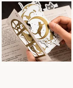 Macro shot of semi-transparent cat and moon stickers with gold foil details on a book