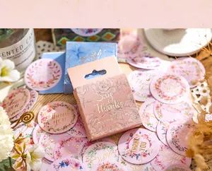 Détail d'autocollants floraux avec texte doré Say Thanks dans une boîte rose