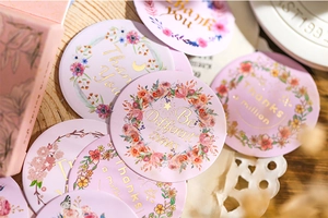 Detailed view of floral thank you stickers with gold foil accents and matching gift box