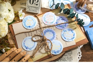 Detail of floral wreath gift stickers with gold foil Thank You text on vintage background
