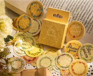Détail d'autocollants de couronnes florales vintage avec dorure sur des pages