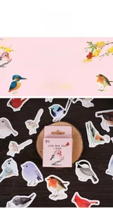Detailed view of little birds chirp colorful stickers on dark wood grain background