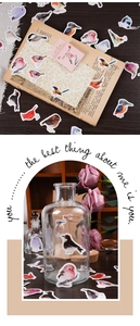 Detailed view of little bird stickers used on a glass bottle for DIY craft decoration