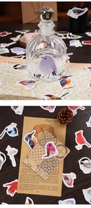 Macro shot of colorful bird stickers on vintage envelopes and glass jars for scrapbooking