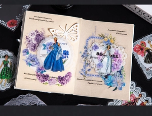 Dettaglio di adesivi vintage a tema balletto con fiori blu e carta pizzo per scrapbooking