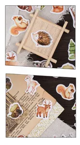 Flat lay of forest animal stickers like deer and squirrels on a vintage book page