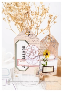 Close-up of vintage tags with twine and floral motifs for scrapbooking and gifts