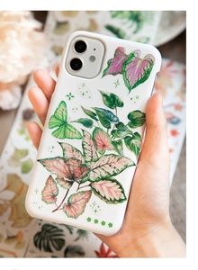 Detailed view of white iPhone case featuring delicate green leaves and butterfly motifs