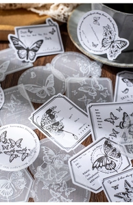 Detalle de pegatinas de mariposas vintage con papel vellum en escritorio de madera