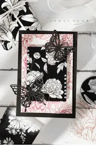 Detail of floral junk journal paper with black butterfly cutouts and pearl accents