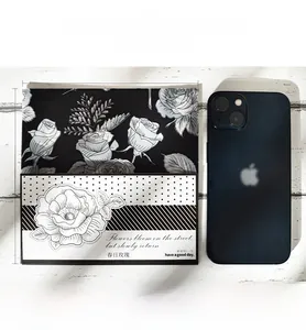 Detail of 150mm vintage floral scrapbooking paper with black rose patterns on a wood background