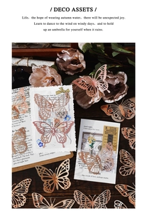 Detailed laser-cut rose gold butterfly scrapbooking charms in vintage aesthetic scene
