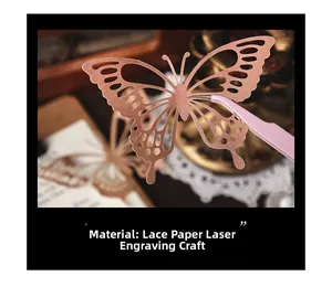 Close-up of tweezers holding laser-cut rose gold lace paper butterfly for DIY scrapbooking
