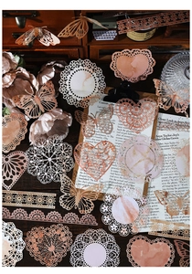 Detailed view of vintage lace paper doilies and butterfly cutouts for DIY scrapbooking