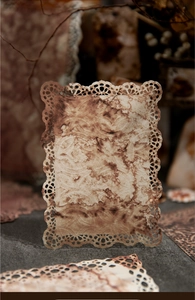 Detail of vintage laser-cut lace paper with distressed texture for journaling