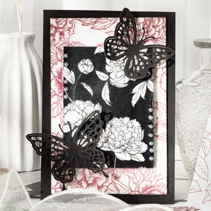 Artistic botanical scrapbook paper with black laser-cut butterflies and floral patterns