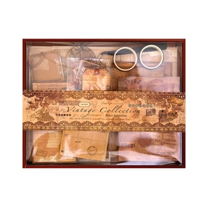 Vintage scrapbooking kit with stickers, background paper, tapes and tweezers in a gift box