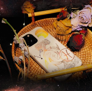 Detail of Piscean phone case with gold foil waves and zodiac symbols in a rustic basket