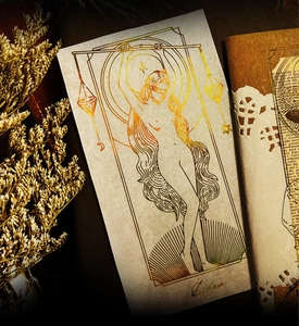Detail of Libra zodiac gold-stamped card with dried flowers and vintage notebook