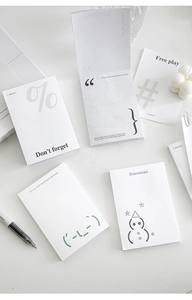 Detail view of minimalist symbol notepad sheets with elegant typography and snowman illustration