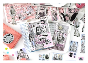 Flat lay of Gothic Lolita stationery set including stickers, notebook and acrylic stand
