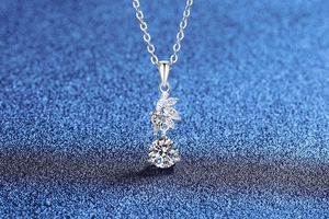Macro shot of S925 silver necklace with marquise moissanite leaves and round pendant