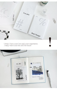 Close-up of minimalist symbol memo pads and scrapbooking stickers in a desk layout