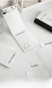 Macro view of minimalist white notepad set featuring large grey punctuation designs