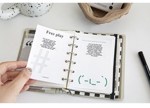 Detailed view of 6-ring silver binder notepad with checkerboard pattern and grid pages