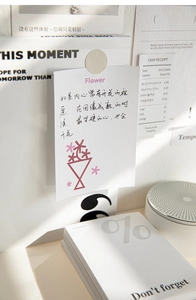 Detail of basic symbol memo pad and decorative card with floral illustration on a desk
