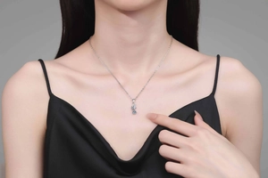 Close-up of double-layered floral s925 silver necklace with blue moissanite on model