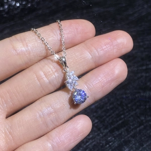 S925 sterling silver moissanite necklace featuring a round main stone held by a hand