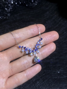Close-up of S925 silver necklace with V-shaped blue and white moissanite pendant