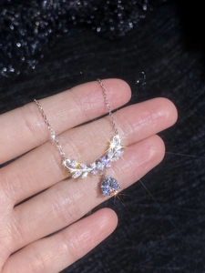 Macro shot of 1 carat Moissanite pendant with sparkling floral accents held in hand