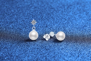 Detailed close-up of S925 sterling silver star stud earrings with white pearls and moissanite